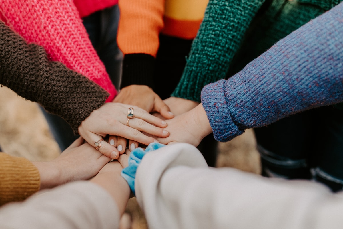 A diverse team of caregivers joining hands together